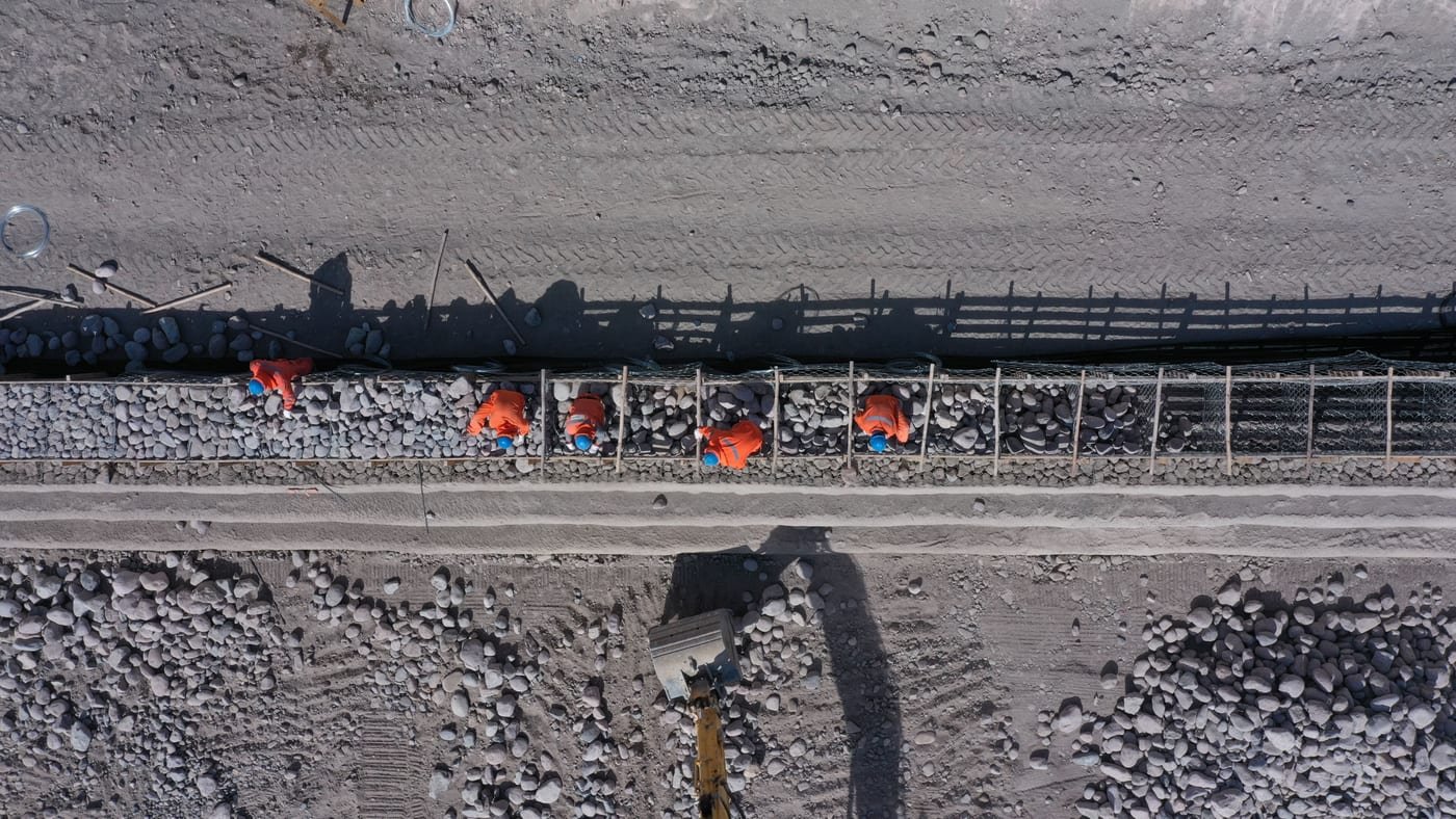 Vista cenital de canal o zanja estrecha con trabajadores, Valle del Choapa