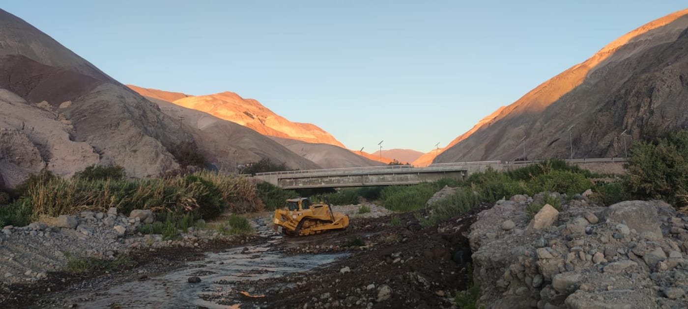 Cauce seco en cañón con maquinaria trabajando al fondo, Región de Coquimbo