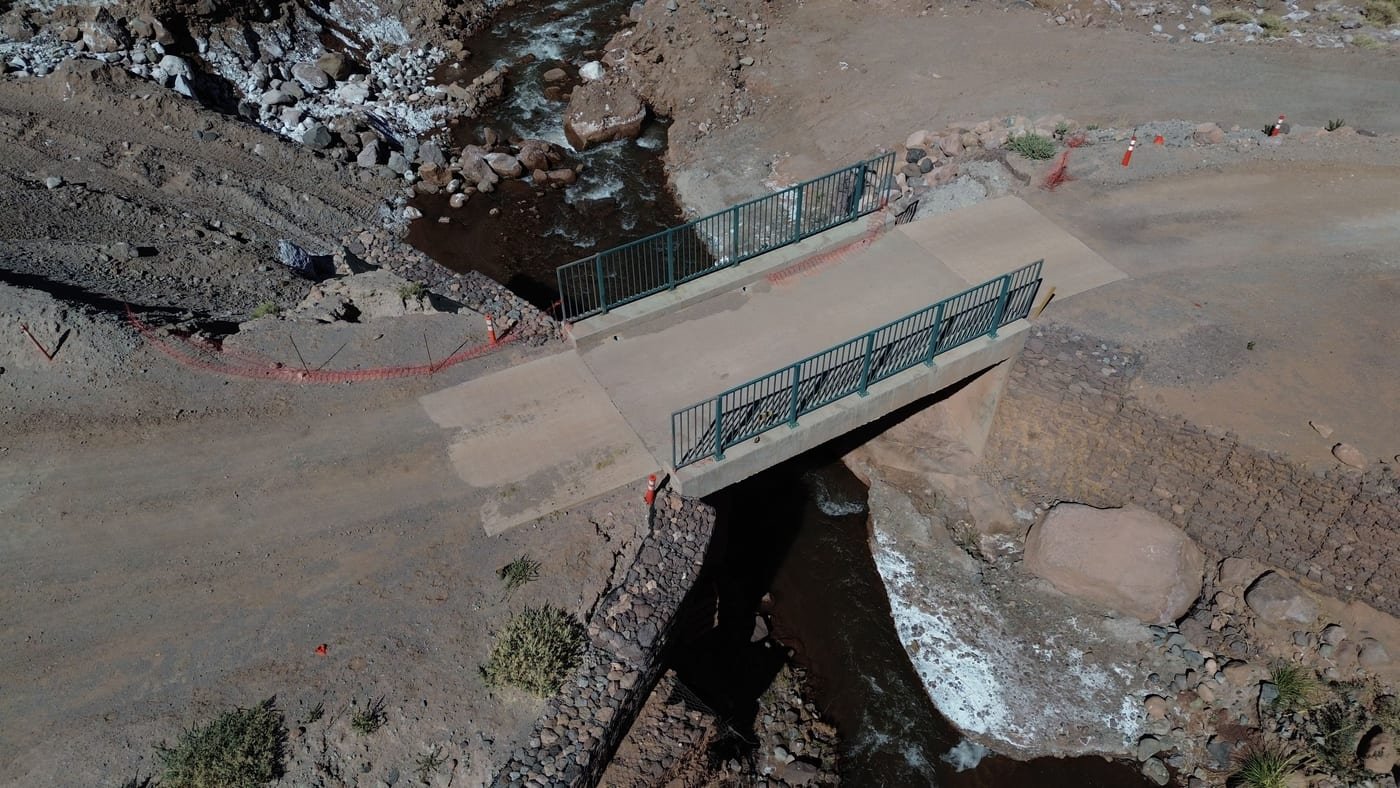 Vista aérea de puente de concreto cruzando un río, obras civiles Ara-Chile