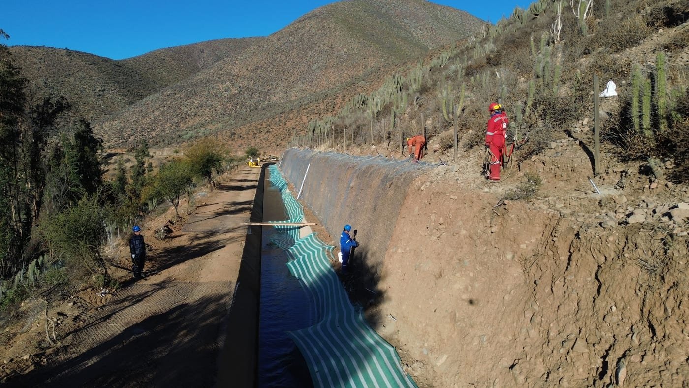 Trabajadores instalando revestimiento en canal, faena Ara-Chile